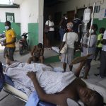 
              A person injured from the earthquake lies on a stretcher as another who was injured in a car accident sits behind, at the General Hospital in Les Cayes, Haiti, Wednesday, Aug. 18, 2021. (AP Photo/Fernando Llano)
            