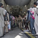 
              In this Aug. 21, 2021, image provided by the U.S. Air Force, U.S. Airmen and U.S. Marines guide evacuees aboard a U.S. Air Force C-17 Globemaster III in support of the Afghanistan evacuation at Hamid Karzai International Airport in Kabul, Afghanistan. (Senior Airman Brennen Lege/U.S. Air Force via AP)
            