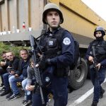 
              Kosovo police officers patrol by trucks where Kosovo Serbs block a road near the northern Kosovo border crossing of Jarinje, Monday, Sept. 20, 2021. Tensions soared Monday at the border between Kosovo and Serbia as Kosovo deployed additional police to implement a rule to remove Serbian license plates from cars entering Kosovo, while Serbs protested the move. (AP Photo/Bojan Slavkovic)
            