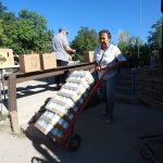 
              Barrios Unidos president Lupe Salazar pushes a dolly filled with canned food ahead of a food drive on Thursday, Sept. 23, 2021, in Chimayó, New Mexico. (AP Photo/Cedar Attanasio)
            