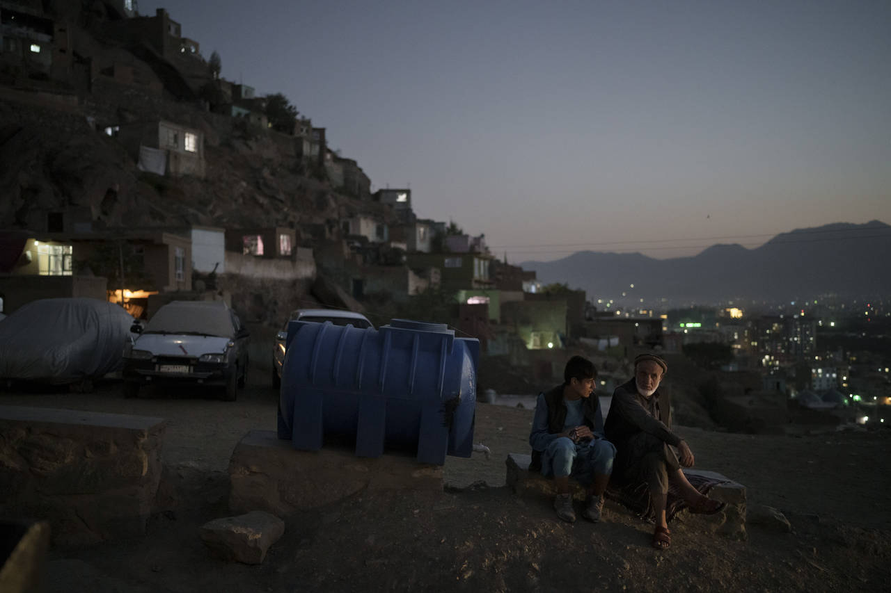 Afghans sit on the side of a road at dusk in Kabul, Afghanistan, Tuesday, Sept. 14, 2021. The Unite...