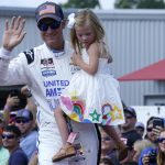 
              Dale Earnhardt Jr., holds his daughter Isla, 3, during driver introductions before the NASCAR Xfinity auto race in Richmond, Va., Saturday, Sept. 11, 2021. (AP Photo/Steve Helber)
            