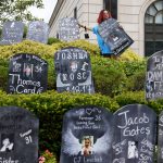 
              FILE - In this Aug. 9, 2021, file photo, Jayde Newton helps to set up cardboard gravestones with the names of victims of opioid abuse outside the courthouse where the Purdue Pharma bankruptcy is taking place in White Plains, N.Y. A federal bankruptcy judge on Wednesday, Sept. 1, gave conditional approval to a sweeping, potentially $10 billion plan submitted by OxyContin maker Purdue Pharma to settle a mountain of lawsuits over its role in the opioid crisis that has killed a half-million Americans over the past two decades. (AP Photo/Seth Wenig, File)
            