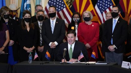 FILE - In this April 15, 2021, file photo, surrounded by Arizona legislators, Republican Arizona Go...