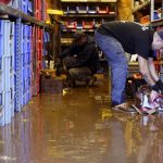 Louis Dearani, Jr., right, helps to clean up after his family business, United Automatic Fire Sprinkler, was flooded from the remnants of Hurricane Ida that hit the area  in Woodland Park, N.J., Thursday, Sept. 2, 2021. (AP Photo/Seth Wenig)