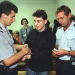 
              FILE - In this July 16, 1997 file photo, police handcuff Lionel Dumont of France after his trial in central Bosnian town of Zenica for a series of robberies in Bosnia. Dumont, a senior al-Qaida member, was based in Japan for more than a year, and investigators suspect he was trying to establish a terror cell, Japanese media said Tuesday, May 18, 2004. (AP Photo/Hidajet Delic, File)
            