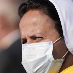 
              A nun wears a face mask to curb the spread of the coronavirus as she waits for Pope Francis to arrive to celebrate a Byzantine rite Mass at Mestska sportova hala Square, in Presov, Slovakia, Tuesday, Sept. 14, 2021. Pope Francis is on a four-day pilgrimage to Hungary and Slovakia. (AP Photo/Darko Vojinovic)
            