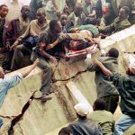 FILE - In this Friday, Aug. 7, 1998 file photo, rescue workers carry Susan Francisca Murianki, a U.S. embassy office worker, over the rubble of a collapsed building next to the embassy, in Nairobi, Kenya. In 1996, Osama bin Laden issued a formal declaration of war. But it wasn't until trucks loaded with explosives detonated outside of U.S. embassies in Nairobi and Dar es Salaam, Tanzania, killing more than 200 people on Aug. 7, 1998, that the threat became real. (AP Photo/Khalil Senosi, File)