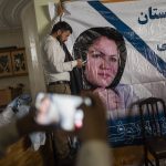 
              A man holds a poster of Afghan politician Fawzia Koofi prior to a press conference organized by the "movement of change for Afghanistan Party" in Kabul, Afghanistan, Sunday, Sept. 19, 2021. (AP Photo/Bernat Armangue)
            