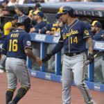 
              Milwaukee Brewers' Jace Peterson (14) congratulates Kolten Wong for scoring on a triple by Christian Yelich during the first inning of a baseball game against the Cleveland Indians in Cleveland, Saturday, Sept. 11, 2021. (AP Photo/Phil Long)
            