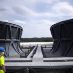 
              A worker surveys the cooling tower area of the ITER machine in Saint-Paul-Lez-Durance, France, Thursday, Sept. 9, 2021. Scientists at the International Thermonuclear Experimental Reactor in southern France took delivery of the first part of a massive magnet so strong its American manufacturer claims it can lift an aircraft carrier. (AP Photo/Daniel Cole)
            