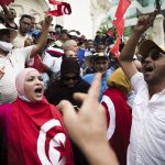 
              Tunisian demonstrators chant slogans during a protest against Tunisian President Kais Saied, Saturday, Sept. 18, 2021 in Tunis. In July Tunisian President Kais Saied fired the country's prime minister and froze parliament's activities after violent demonstrations over the country's pandemic and economic situation. The movement made by Saied was considered by his opponents as a coup. (AP Photo/Riadh Dridi)
            