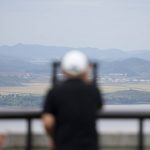 
              A visitor uses binoculars to see the North Korean side from the unification observatory in Paju, South Korea, Tuesday, Sept. 28, 2021. North Korea fired a short-range missile into the sea early Tuesday, its neighboring countries said, in the latest weapon tests by North Korea that has raised questions about the sincerity of its recent offer for talks with South Korea. (AP Photo/Lee Jin-man)
            