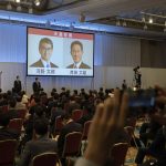 
              The pictures of Liberal Democrat Party leadership candidates Taro Kono, left, and Fumio Kishida are displayed on a screen during the party leadership election in Tokyo Wednesday, Sept. 29, 2021. Japan's governing party vote to pick a new leader entered a second round Wednesday, with the presumed next prime minister facing imminent, crucial tasks such as addressing a pandemic-hit economy and ensuring a strong alliance with Washington amid growing regional security risks. (Carl Court/Pool Photo via AP)
            