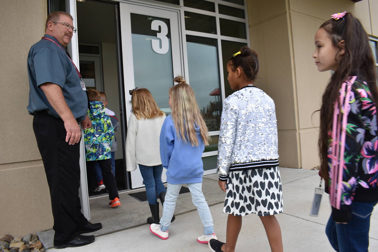 Principal Brad Foss holds the door for students returning from recess at Fox Hills Elementary Schoo...