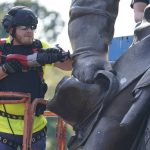 Crews use a saw to cut the statue as they remove one of the country's largest remaining monuments to the Confederacy, a towering statue of Confederate General Robert E. Lee on Monument Avenue in Richmond, Va., Wednesday, Sept. 8, 2021. (AP Photo/Steve Helber)