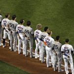 
              The New York Yankees and the New York Mets line up together along the baselines for the 20th anniversary of the 9/11 terrorist attacks before a baseball game on Saturday, Sept. 11, 2021, in New York. (AP Photo/Adam Hunger)
            