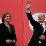 
              Olaf Scholz, Finance Minister and SPD candidate for Chancellor waves to his supporters as he stands next to his wife Britta Ernst after German parliament election at the Social Democratic Party, SPD, headquarters in Berlin, Sunday, Sept. 26, 2021. (AP Photo/Lisa Leutner)
            