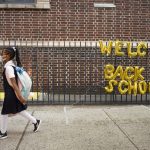 
              FILE - In this Sept. 13, 2021, file photo, a girl passes a "Welcome Back to School" sign as she arrives for the first day of class at Brooklyn's PS 245 elementary school in New York. COVID-19 deaths and cases in the U.S. have climbed back to where they were over the winter, fueled by children now back in their classrooms, loose mask restrictions and low vaccination levels. (AP Photo/Mark Lennihan, File)
            