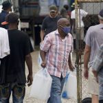 In the aftermath of Hurricane Ida, residence pick up food and ice at a distribution center Wednesday, Sept. 1, 2021, in New Orleans, La. (AP Photo/Eric Gay)