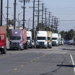 Parked cargo container trucks are seen in a street, Wednesday, Oct. 20, 2021 in Wilmington, Calif. California Gov. Gavin Newsom on Wednesday issued an order that aims to ease bottlenecks at the ports of Los Angeles and Long Beach that have spilled over into neighborhoods where cargo trucks are clogging residential streets. (AP Photo/Ringo H.W. Chiu)