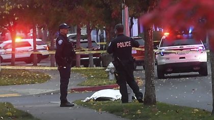 Tacoma police stand by a covered body at the scene of a shooting in Tacoma, Wash. Thursday, Oct. 21...
