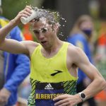 
              CJ Albertson, of Fresno, Calif., pours water on his head while running in the 125th Boston Marathon, Monday, Oct. 11, 2021, in Newton, Mass. (AP Photo/Steven Senne)
            