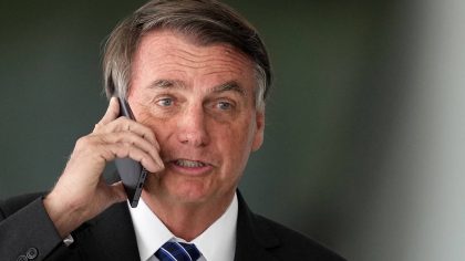 Brazilian President Jair Bolsonaro talks on cell phone after meeting with Colombia's President Ivan...