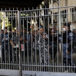 
              Policemen stand guard inside the Justice Palace as supporters of the Shiite Hezbollah and Amal groups protest against Judge Tarek Bitar who is investigating last year's deadly seaport blast, in Beirut, Lebanon, Thursday, Oct. 14, 2021. (AP Photo/Hussein Malla)
            