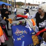 
              Brittanie Hairston, right, hands out candy at a Halloween festival in Charleston, W.Va., on Friday, Oct. 29, 2021. Hairston supported a paid family medical leave proposal that was removed from President Joe Biden's social spending plan because of opposition from West Virginia Sen. Joe Manchin. Hairston said paid leave would ease worries about what would happen in one of her sons got sick. (AP Photo/Jay Reeves)
            