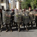 
              Lebanese security forces block a street during a protest in Beirut, Lebanon, Thursday, Oct. 14, 2021. Armed clashes broke out in Beirut Thursday during the protest against the lead judge investigating last year’s massive blast in the city's port, as tensions over the domestic probe boiled over.  (AP Photo/Hussein Malla)
            