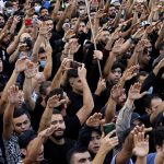 
              Mourners chant slogans as they rise their hands during the funeral of three Hezbollah supporters who were killed during Thursday clashes, in the southern Beirut suburb of Dahiyeh, Lebanon, Friday, Oct. 15, 2021. The government called for a day of mourning following the armed clashes, in which gunmen used automatic weapons and rocket-propelled grenades on the streets of the capital, echoing the nation's darkest era of the 1975-90 civil war. (AP Photo/Bilal Hussein)
            