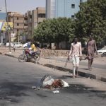 
              People walk on a street in Khartoum, Sudan, two days after a military coup, Wednesday, Oct. 27, 2021. The coup threatens to halt Sudan's fitful transition to democracy, which began after the 2019 ouster of long-time ruler Omar al-Bashir and his Islamist government in a popular uprising. It came after weeks of mounting tensions between military and civilian leaders over the course and pace of that process. (AP Photo/Marwan Ali)
            