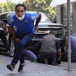 
              A man runs to take cover as supporters of a Shiite group allied with Hezbollah help injured men during armed clashes that erupted during a protest in the southern Beirut suburb of Dahiyeh, Lebanon, Thursday, Oct. 14, 2021. It was not immediately clear what triggered the gunfire, but tensions were high along a former civil war front-line between Muslim Shiite and Christian areas. (AP Photo/Hassan Ammar)
            