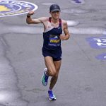 
              Colin Bennie, of the United States, raises his fist as he approaches the finish line at the Boston Marathon in Boston, Monday, Oct. 11, 2021. Bennie finished seventh. (AP Photo/Charles Krupa)
            
