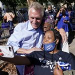 
              FILE - In this Oct. 17, 2021, file photo, Democratic gubernatorial candidate, former Virginia Gov. Terry McAuliffe, left, poses for a photo with supporters after a rally in Norfolk, Va. McAuliffe won Virginia's 2013 governor's race by embracing his own brand of personal politics that rely on decades-old friendships, back-slapping charisma and tell-it-like-it-is authenticity. (AP Photo/Steve Helber, File)
            