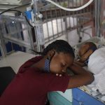 
              A woman rests close to her newborn son at the Saint Damien Pediatric Hospital of Port-au-Prince, Haiti, Sunday, Oct. 24, 2021. Haiti's capital has been brought to the brink of exhaustion by fuel shortages and the capital's main pediatrics hospital says it has only three days of fuel left to run ventilators and medical equipment. (AP Photo/Matias Delacroix)
            