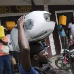 
              A man balances his motorbike tank on his head as he waits outside a gas station in hopes of filling his tank, in Port-au-Prince, Haiti, Saturday, Oct. 23, 2021. The ongoing fuel shortage has worsened, with demonstrators blocking roads and burning tires in Haiti's capital to decry the severe shortage and a spike in insecurity. (AP Photo/Matias Delacroix)
            