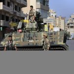 
              Lebanese army soldiers block a road after deadly clashes erupted along a former 1975-90 civil war front-line between Muslim Shiite and Christian areas, in Ain el-Remaneh neighborhood, Beirut, Lebanon, Thursday, Oct. 14, 2021. Armed clashes broke out in Beirut Thursday during the protest against the lead judge investigating last year's massive blast in the city's port, as tensions over the domestic probe boiled over. (AP Photo/Hussein Malla)
            