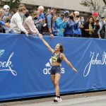 
              American Nell Rojas is congratulated after crossing the finish line of the 125th Boston Marathon on Monday, Oct. 11, 2021, in Boston. (AP Photo/Winslow Townson)
            