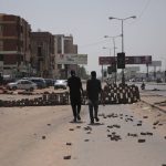 
              People walk on a street in Khartoum, Sudan, two days after a military coup, Wednesday, Oct. 27, 2021. The coup threatens to halt Sudan's fitful transition to democracy, which began after the 2019 ouster of long-time ruler Omar al-Bashir and his Islamist government in a popular uprising. It came after weeks of mounting tensions between military and civilian leaders over the course and pace of that process. (AP Photo/Marwan Ali)
            