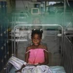 
              A girl rests on a bed as she listens to music at the Saint Damien Pediatric Hospital of Port-au-Prince, Haiti, Sunday, Oct. 24, 2021. Haiti's capital has been brought to the brink of exhaustion by fuel shortages and the capital's main pediatrics hospital says it has only three days of fuel left to run ventilators and medical equipment. (AP Photo/Matias Delacroix)
            