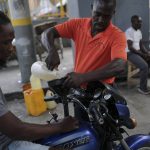 
              A man pours a small amount of gasoline into a motorcycle's fuel tank amid gas shortages during the general strike in Port-au-Prince, Haiti, Monday, Oct. 18, 2021. Workers angry about the nation's lack of security went on strike in protest two days after 17 members of a US-based missionary group were abducted by a violent gang. (AP Photo/Matias Delacroix)
            