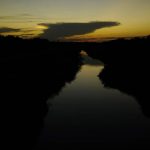 
              The sun sets over a canal, Tuesday, Sept. 14, 2021, in McAllen, Texas. Canals used to deliver water in many parts of the Rio Grande Valley lose anywhere from 10% to 40% of the water they carry to seepage and evaporation, according to the Texas Water Development Board, making water a growing concern amid climate change and rising demand that scientists predict will lead to water shortages in the region by 2060. (AP Photo/Eric Gay)
            