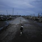 
              A street dog walks at dusk through the abandoned Villa Epecuen, Argentina, Saturday, Sept. 11, 2021. The Argentine spa town was a mecca of tourism for much of the 20th century, until the adjoining lake poured through a broken embankment in 1985 and destroyed hotels, restaurants and other buildings. (AP Photo/Natacha Pisarenko)
            