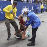 
              Madeleine Rouse of Plano, Texas gets assistance after finishing the 125th Boston Marathon on Monday, Oct. 11, 2021, in Boston. (AP Photo/Winslow Townson)
            