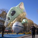 
              Police walk by an inflated helium balloon of Grogu, also known as Baby Yoda, from the Star Wars show The Mandalorian, Wednesday, Nov. 24, 2021, in New York, as the balloon is readied for the Macy's Thanksgiving Day Parade on Thursday. (AP Photo/Ted Shaffrey)
            