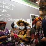 
              Members of the International Indigenous People's Forum on Climate Change look at their phones at the COP26 U.N. Climate Summit, in Glasgow, Scotland, Wednesday, Nov. 3, 2021. The U.N. climate summit in Glasgow gathers leaders from around the world, in Scotland's biggest city, to lay out their vision for addressing the common challenge of global warming. (AP Photo/Alberto Pezzali)
            