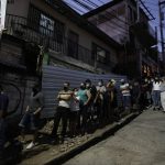 
              People line up outside a polling station after closing time to vote during general elections in Tegucigalpa, Honduras, Sunday, Nov. 28, 2021. The National Electoral Council announced that polling stations that still had people waiting outside to vote should stay open until all had a chance to cast their ballots. (AP Photo/Moises Castillo)
            