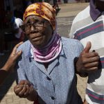 
              An elderly woman is assisted after casting her vote during local elections in Soweto, South Africa, Monday, Nov. 1, 2021. South Africa is holding crucial local elections Monday, the country has been hit by a series of crippling power blackouts that many critics say highlight poor governance. (AP Photo/Denis Farrell)
            